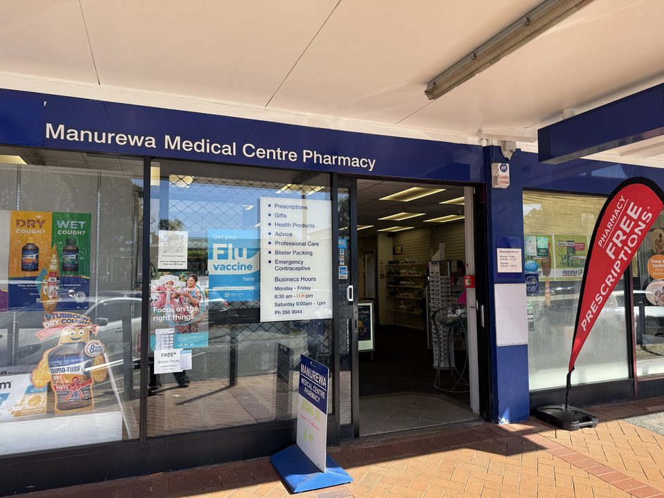 The pharmacy entrance on Great South Road, with the opening hours and services listed on the window